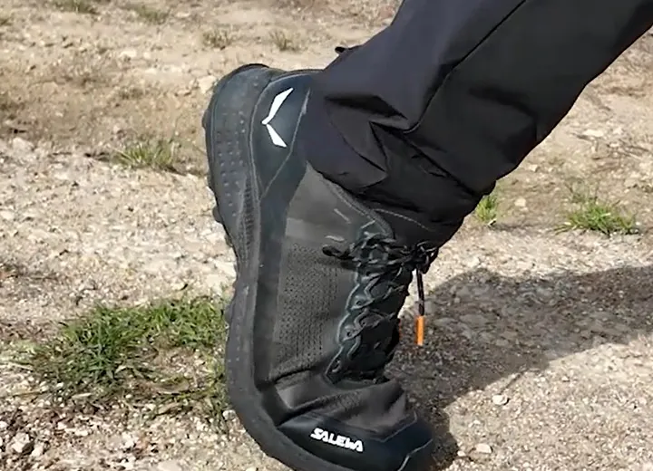 Pied chaussé d’une chaussure de trail basse qui se plie sur un sentier, en marche nordique