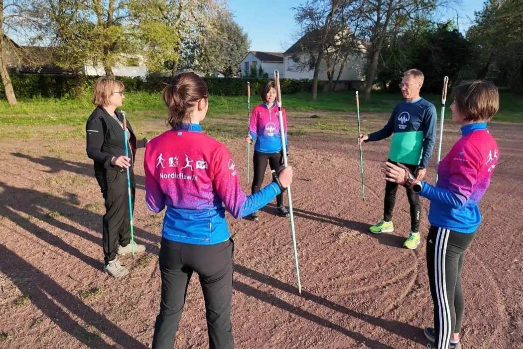 Groupe de marche nordique en cercle avec les bâtons avant l'échauffement