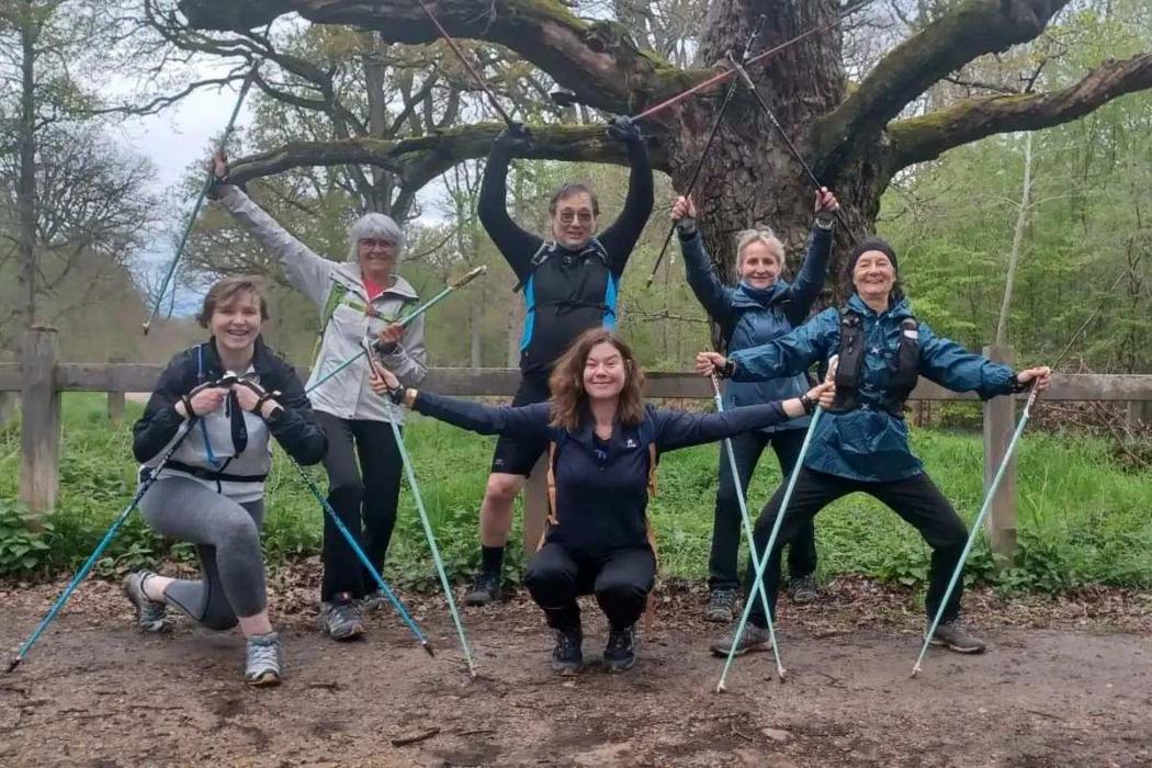 Squat avec appui sur les bâtons pendant l'échauffement de marche nordique