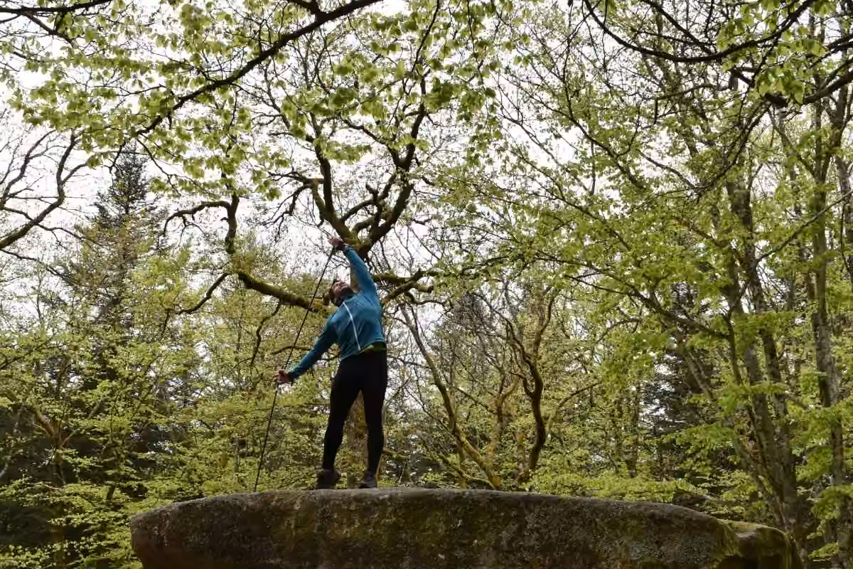 Kévin Richard en équilibre sur un rocher dans une forêt claire