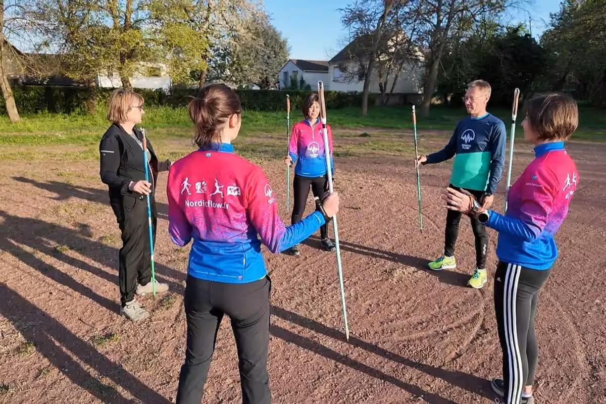 Participants en cercle avec bâtons en vestes Nordic Flow