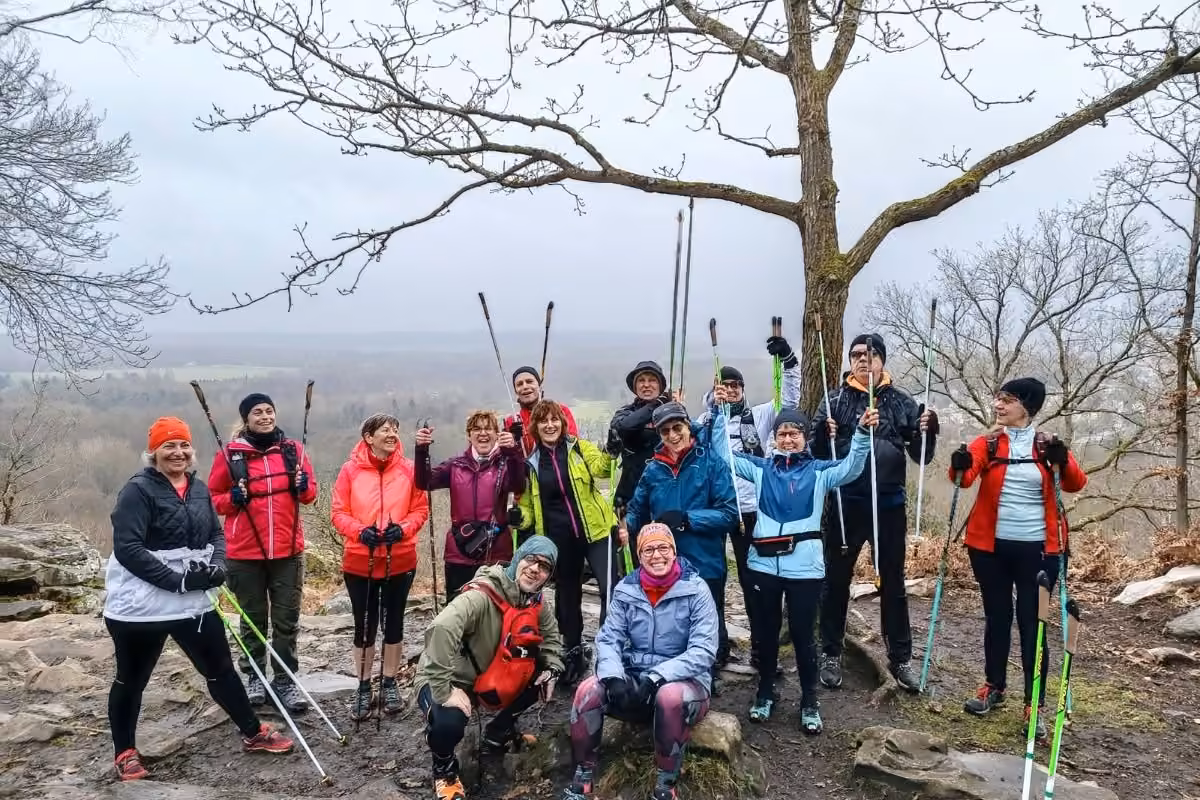 Groupe de marche nordique sous un arbre mort, vue dégagée sur la campagne