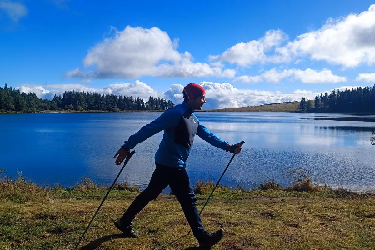 Kévin Richard en marche nordique au bord du lac de la Servière : grande foulée, poussée active sur les bâtons