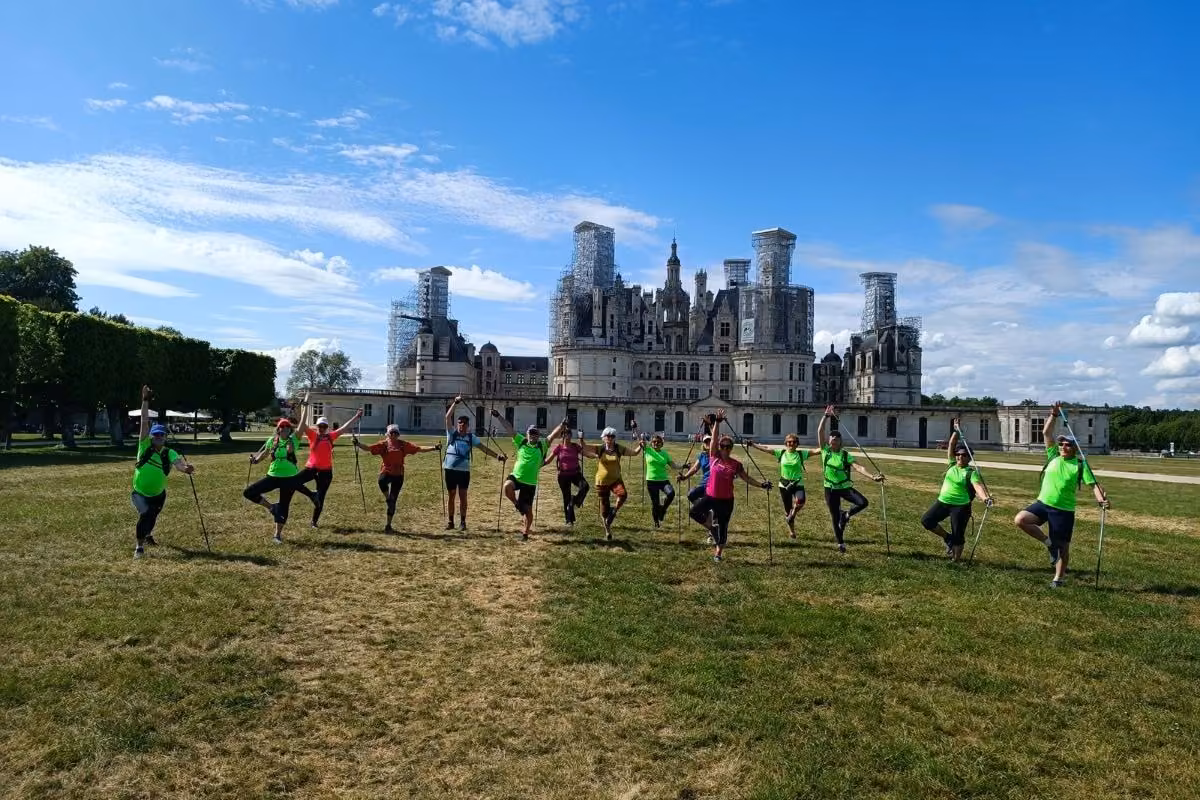 Groupe en équilibre aligné, bâtons levés, sur la pelouse d'un château