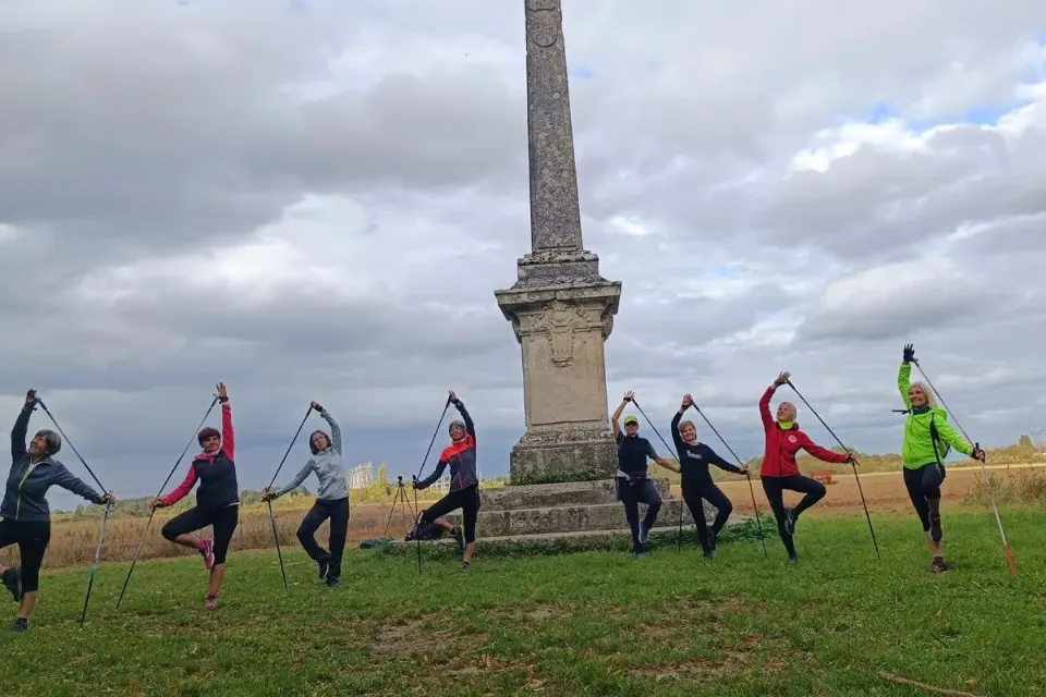 Participantes en posture de l’arbre avec bâtons de marche nordique au pied de l’obélisque du parc de Sceaux