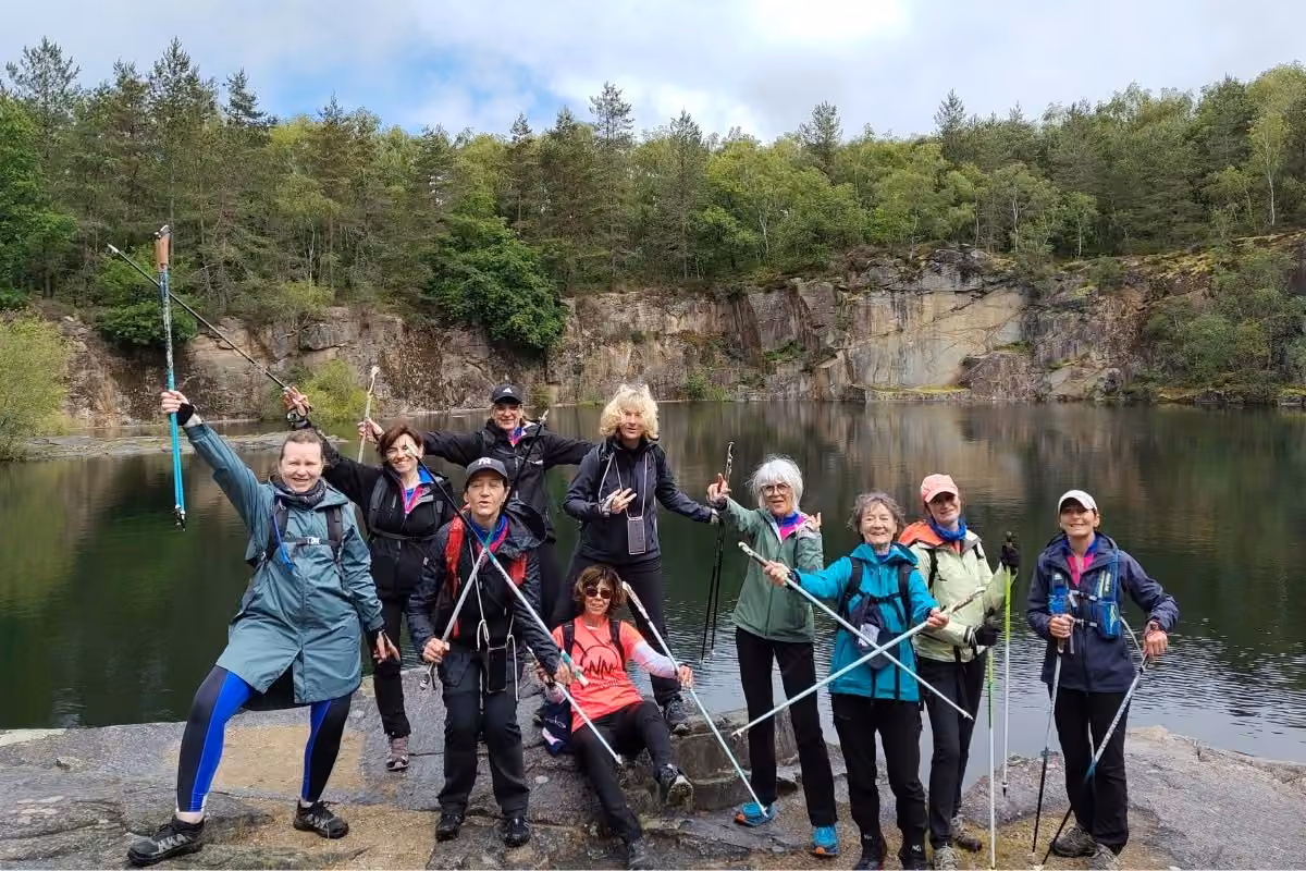 Groupe posant au bord d'un lac de carrière en Creuse, bâtons levés