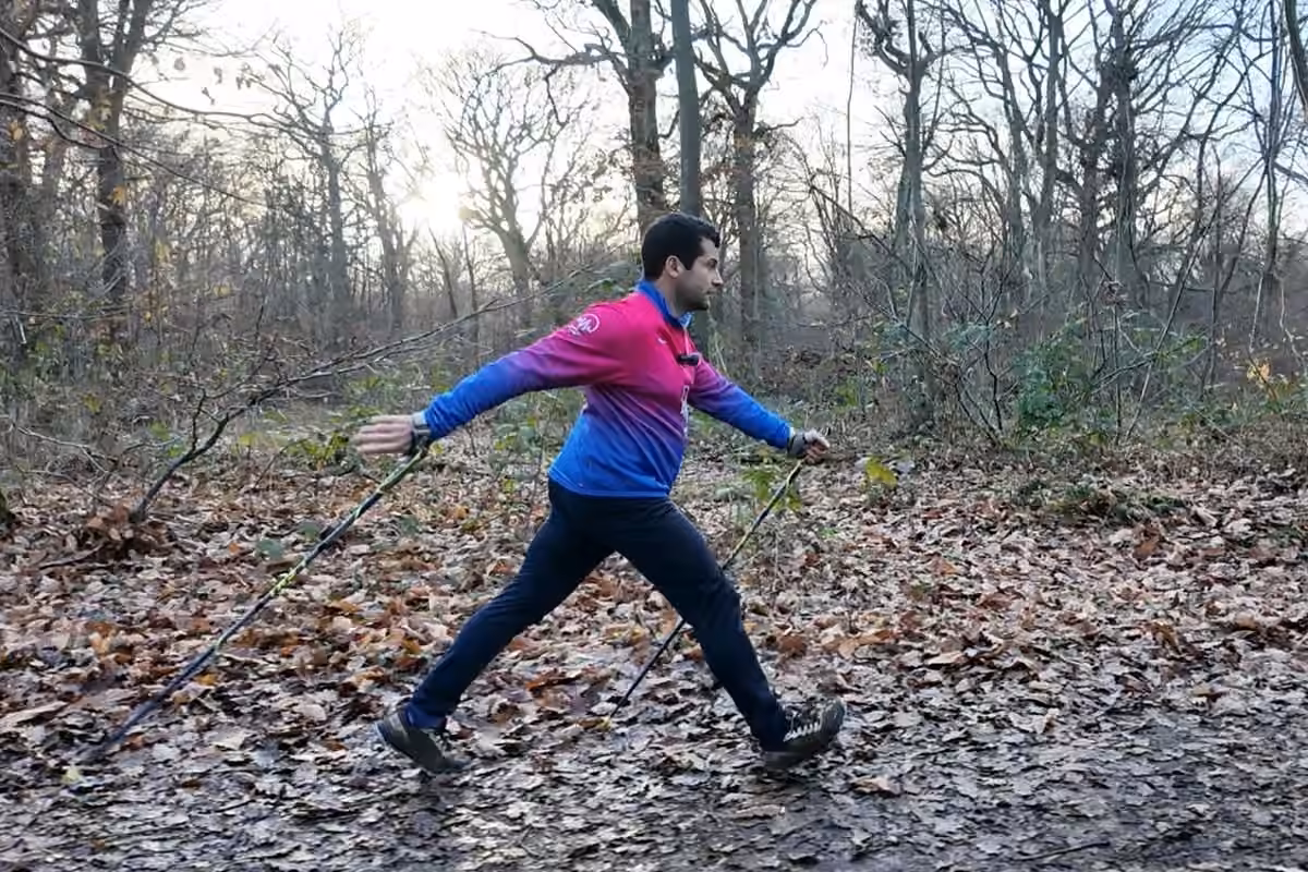 Technique de marche nordique : poussée complète du bras sur un sentier de feuilles mortes